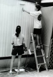 Two campers painting a wall