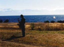 Photo: John Tank playing his sax by the ocean